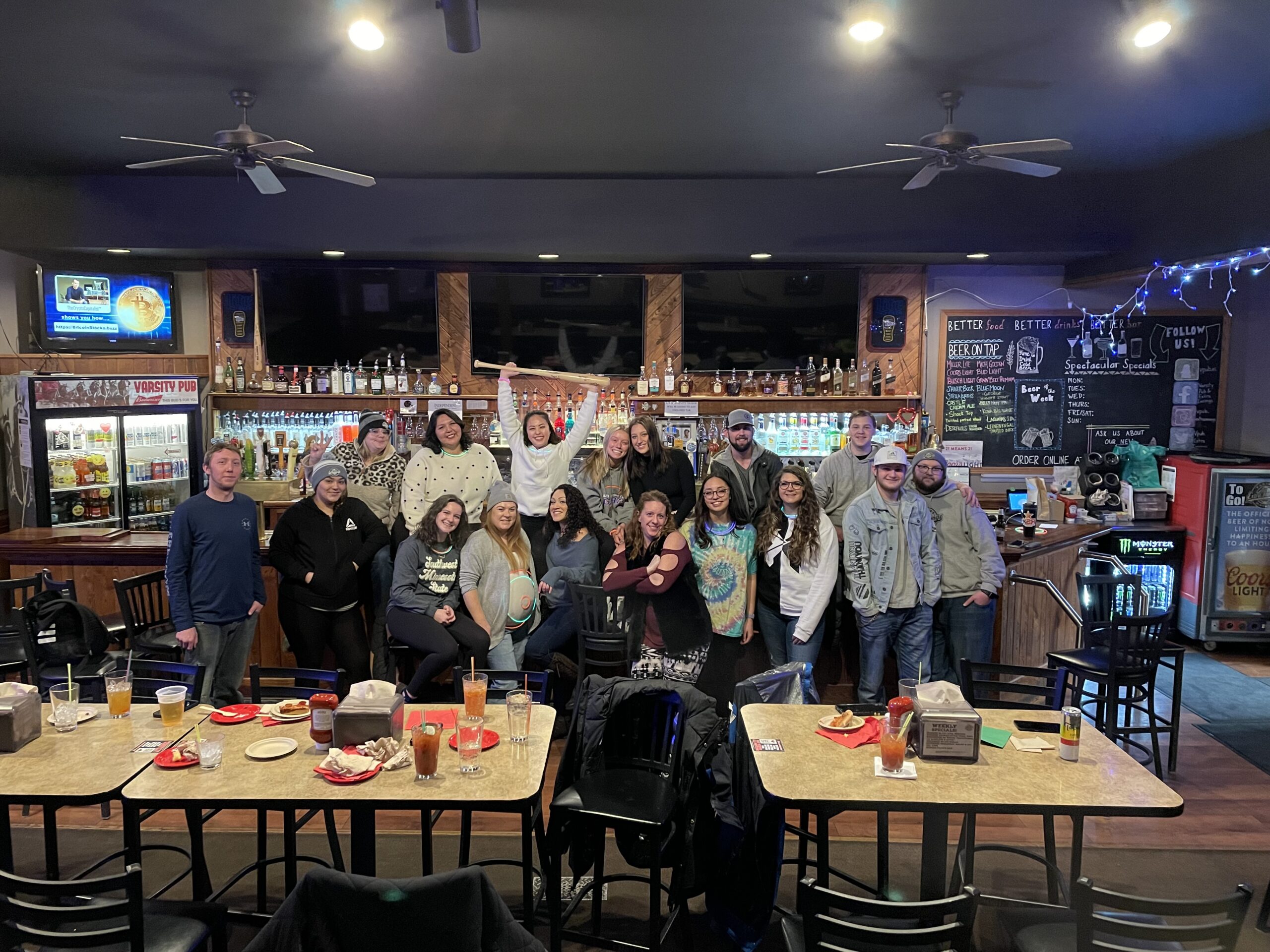 A group of enthusiastic employees gathered at the bar they work at